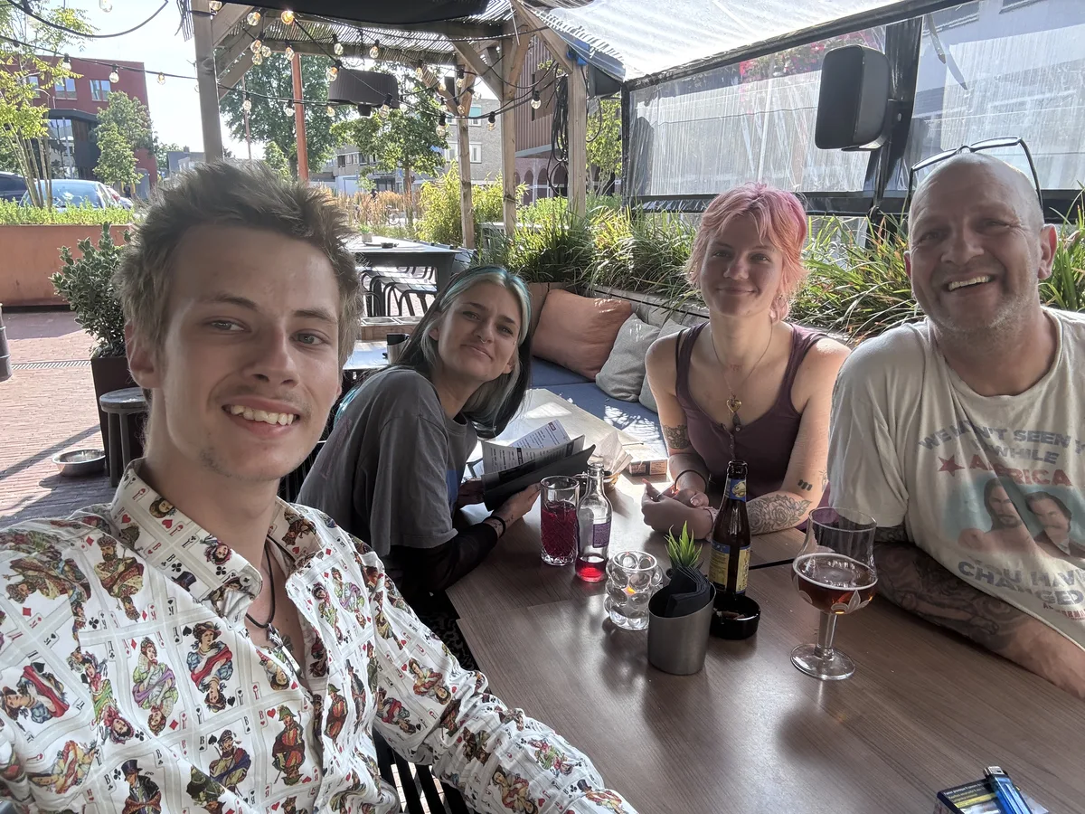 Sara with her brother and sister and their father in a group selfie on a terrace