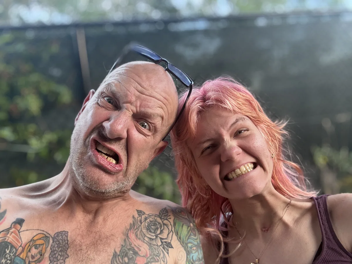 Sara and her father, faces squeezed together, fourth frame of the burst